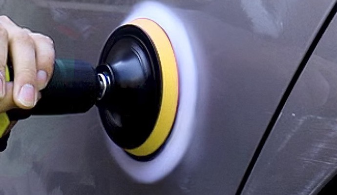 Drill polishing pad working a gray door panel