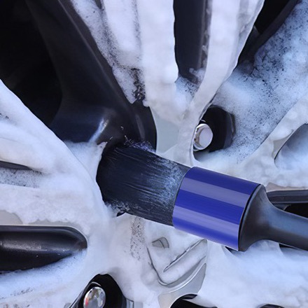 Detailing brush cleaning a foamed alloy wheel